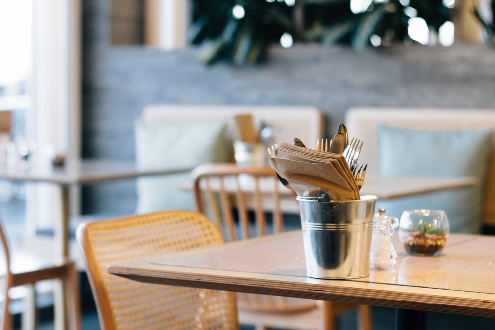 a table in a restaurant with some cutlery and napkins 